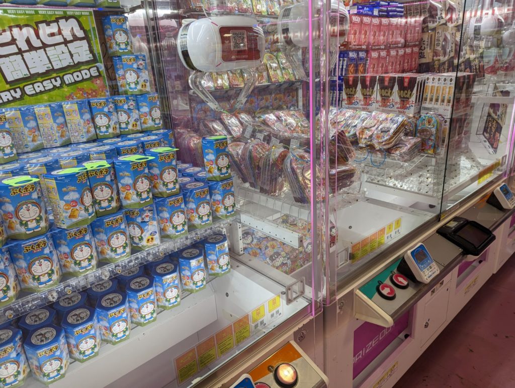 Ein UFO-Catcher, in dem man sich Süßigkeiten greifen kann.