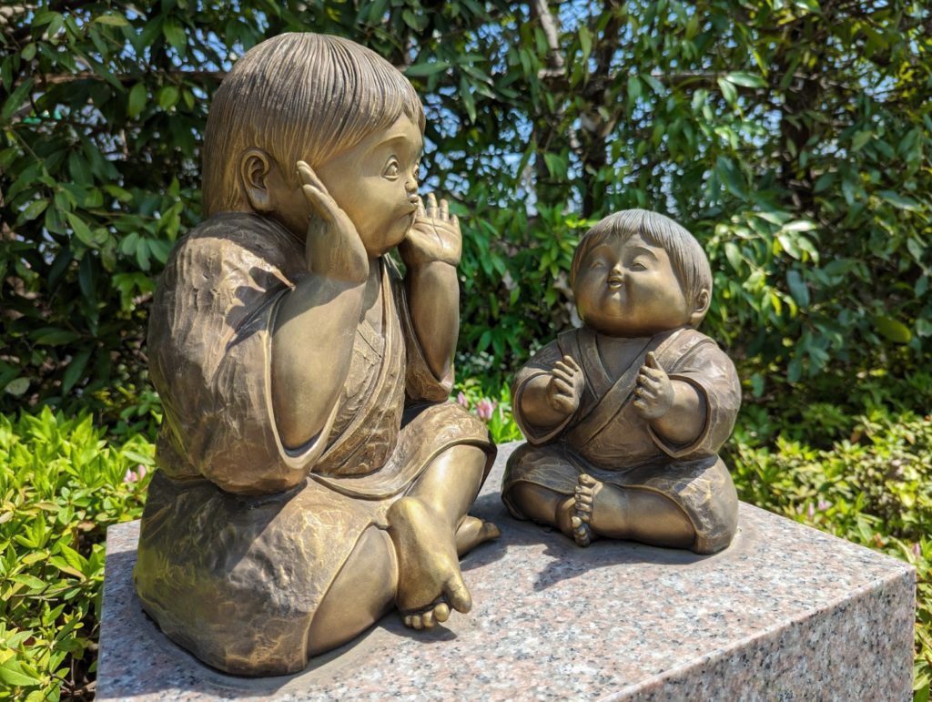 Eine Statue zweier Kinder, die miteinander spielen im Garten des Risshō Kōsei Kai