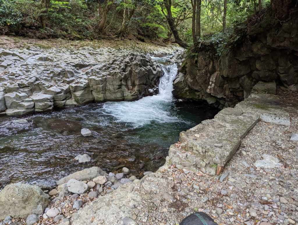 Ein kleiner wasserfall zwicshen breiteren Felsformationen.