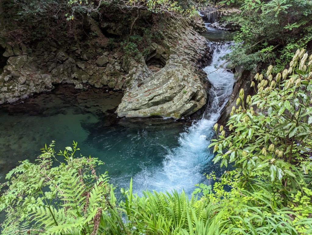 Der Flusslauf ergießt sich über einen kleinen Wasserfall in ein größeres Becken.