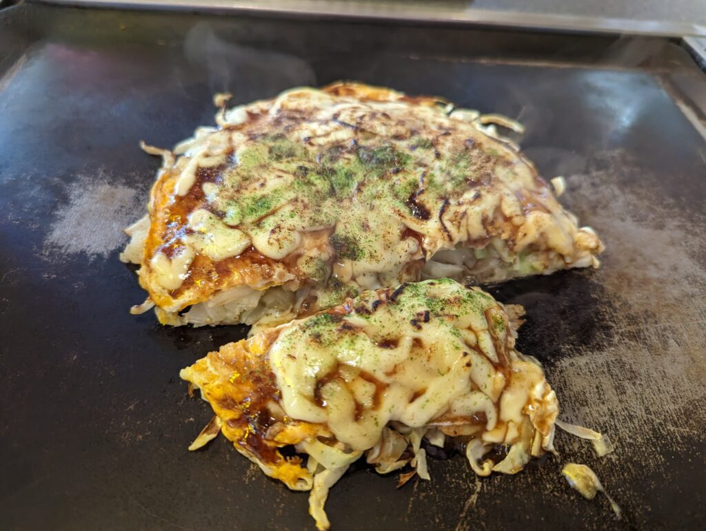 Okonomiyaki auf einer Grillplatte.