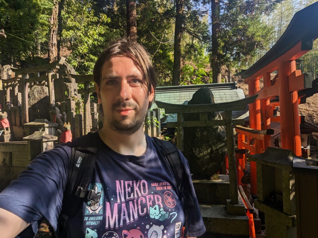 Eine Art Friedhof mit engen Wegen und roten Torii dazwischen beim Fushimi Inari. Der Autor macht ein Selfie